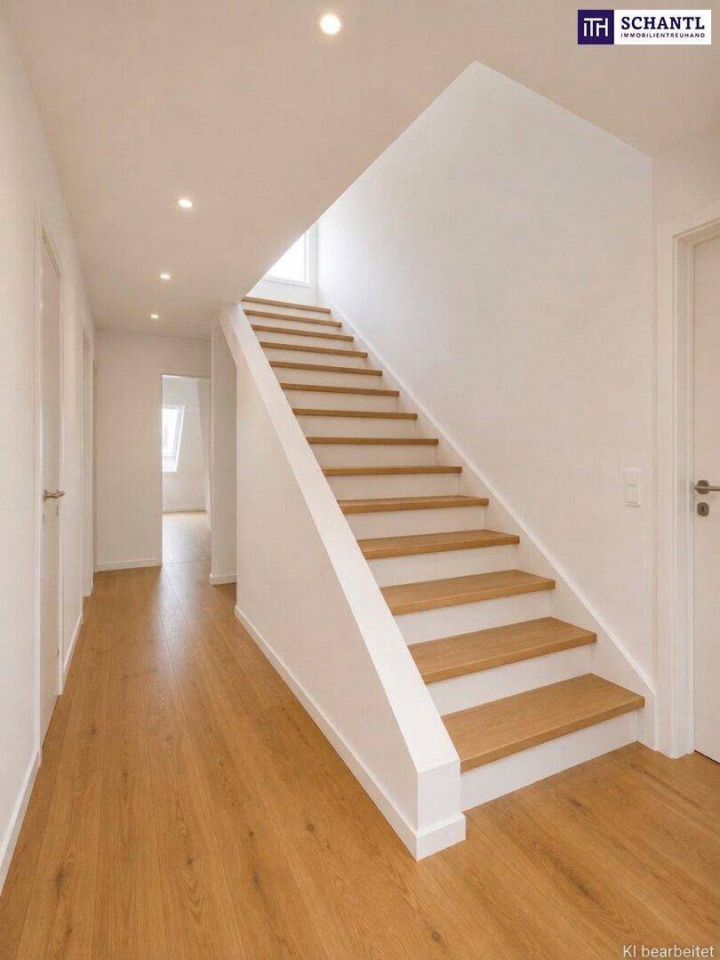 Heller Flur mit Holztreppe und Einbaustrahlern, der zu weiteren Räumen führt.