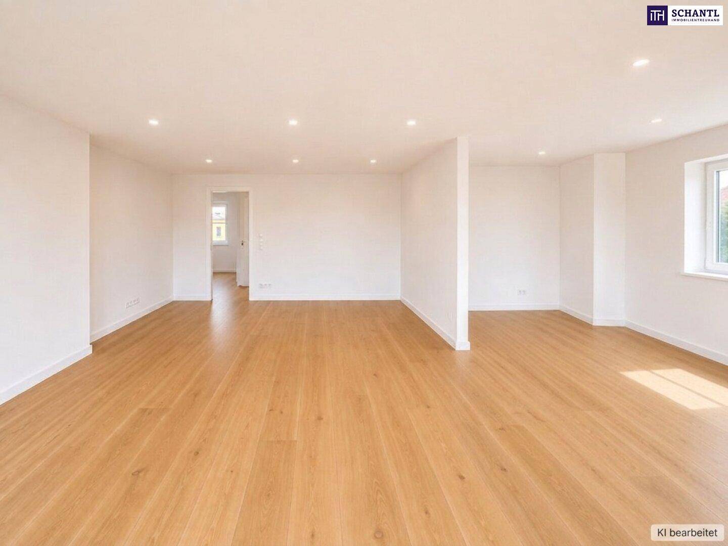 Geräumiger, heller Wohnraum mit Holzparkettboden und Einbaustrahlern an der Decke.