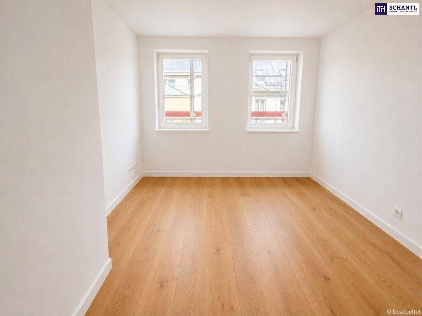 Helles Schlafzimmer mit Holzparkettboden und zwei Fenstern mit Stadtblick.