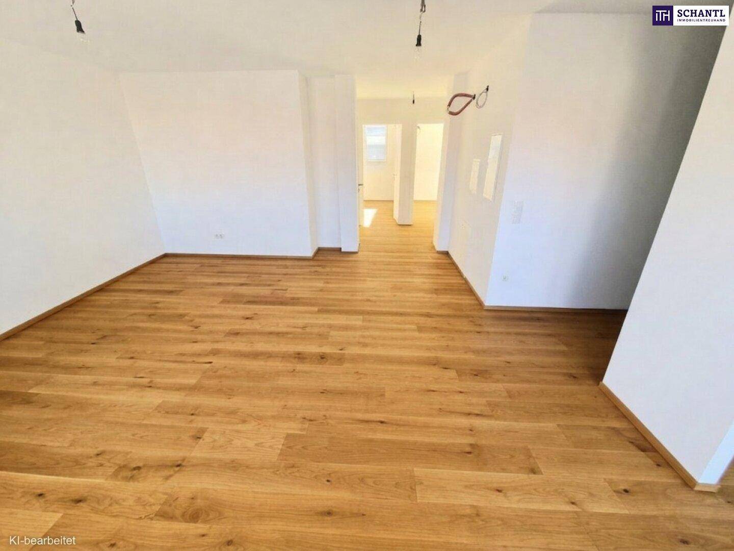 Heller, leerer Raum mit neuem Holzfußboden und weißen Wänden, bereit für die individuelle Gestaltung.