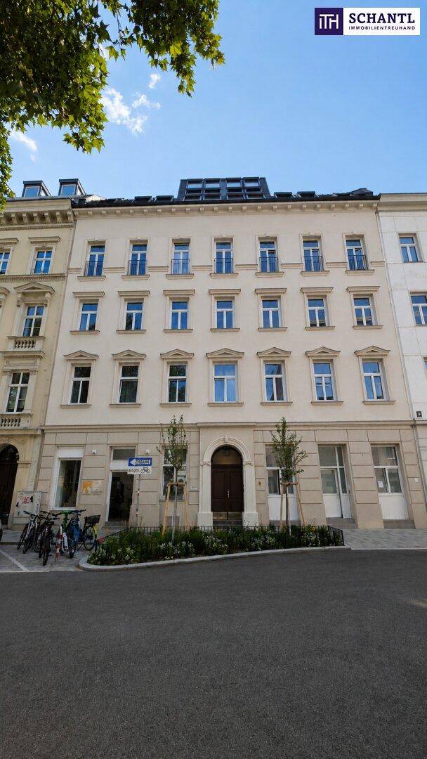 Klassische Fassade eines Mehrfamilienhauses mit vielen Fenstern und einem modernen Dachausbau.