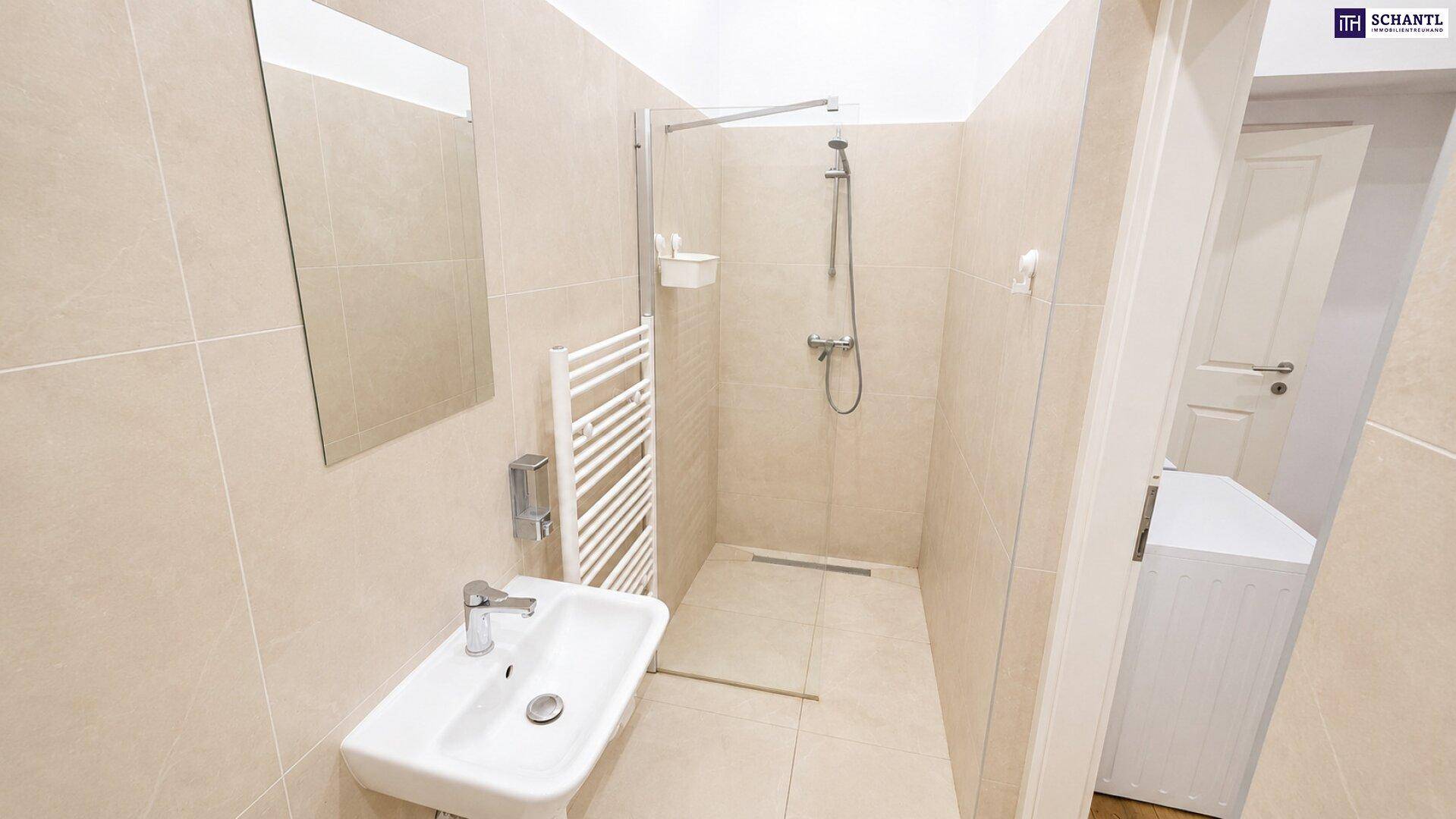 Modernes Badezimmer mit beigefarbenen Fliesen, ebenerdiger Dusche und beheiztem Handtuchhalter.