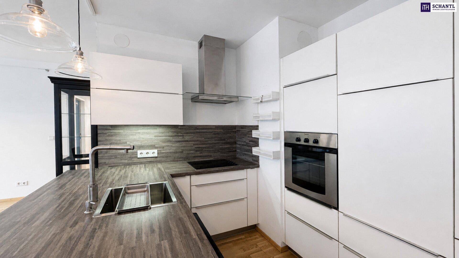 Detailansicht der modernen Küche mit Spüle, Induktionskochfeld und Backofen.