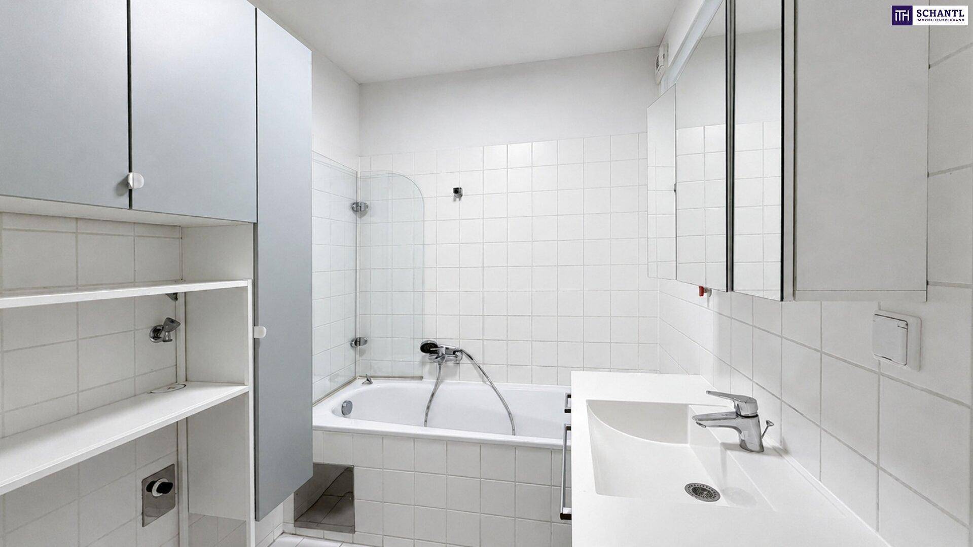 Badezimmer mit weißen Fliesen, Badewanne mit Duschfunktion und Waschbecken.