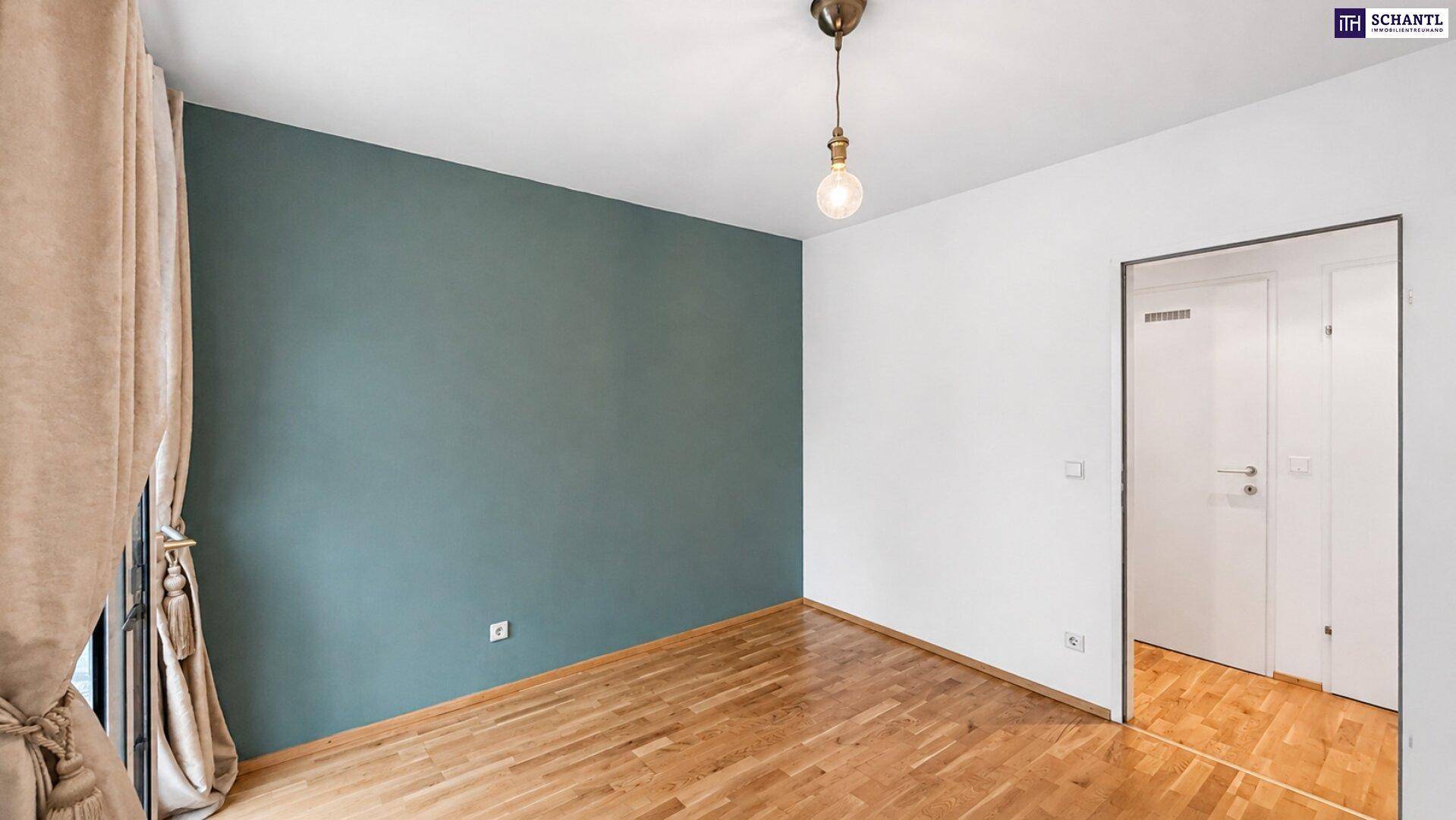 Geräumiges Schlafzimmer mit Holzboden und einer Wand in beruhigendem Grünton.
