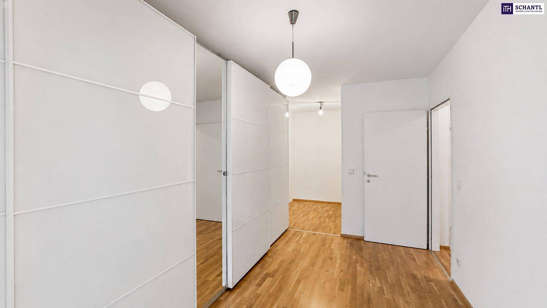 Helles Schlafzimmer mit praktischen Einbauschränken und Holzboden.