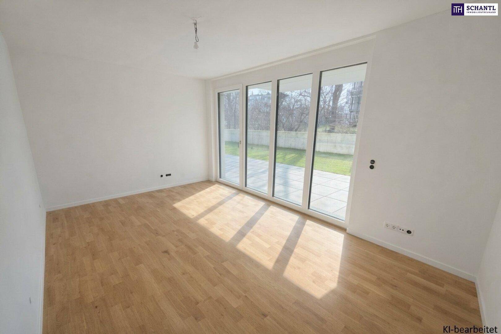 Heller Raum mit Holzboden und großen Glasfronten, die Zugang zur Terrasse und zum Garten bieten.