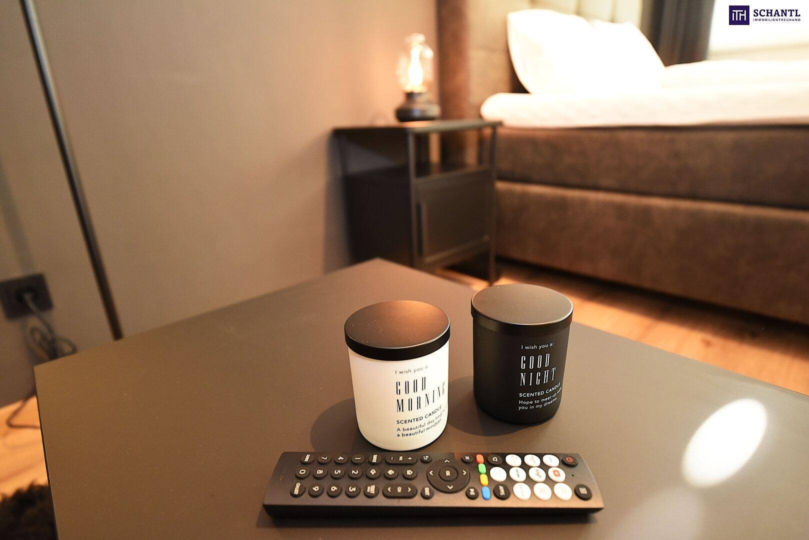 Nahaufnahme eines Couchtisches mit Kerzen und einer Fernbedienung in einem modernen Wohnbereich.