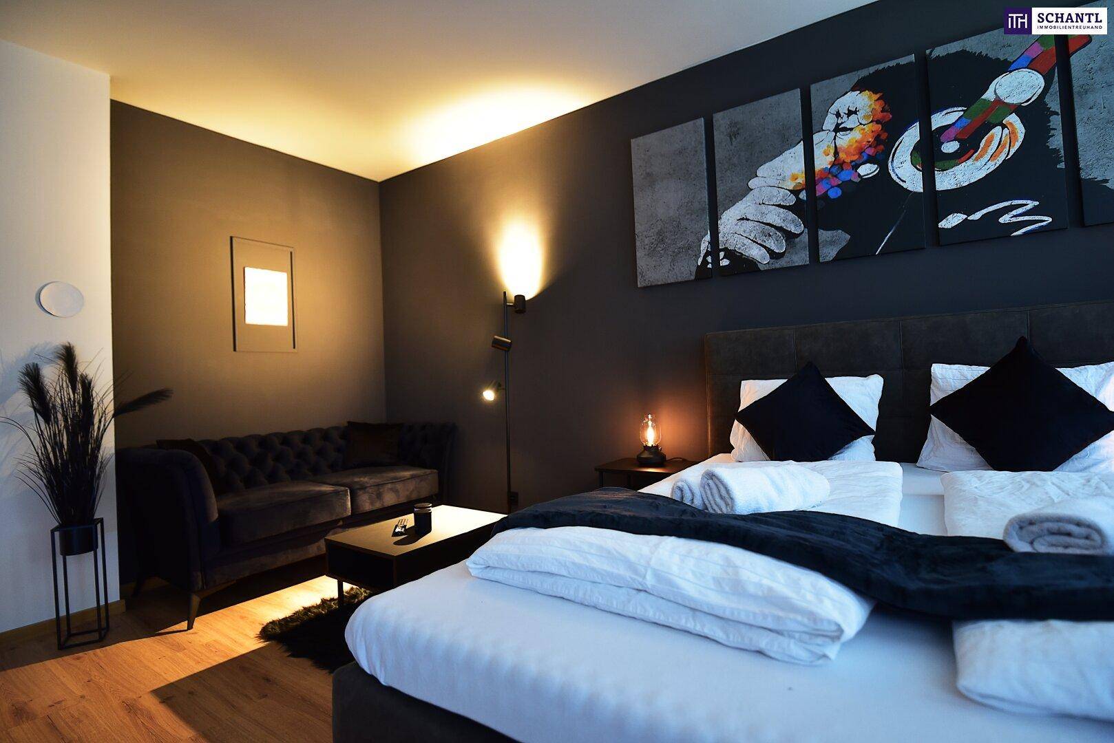 Gemütliches Schlafzimmer mit dunklen Wänden, großem Bett und stilvoller Kunst an der Wand.