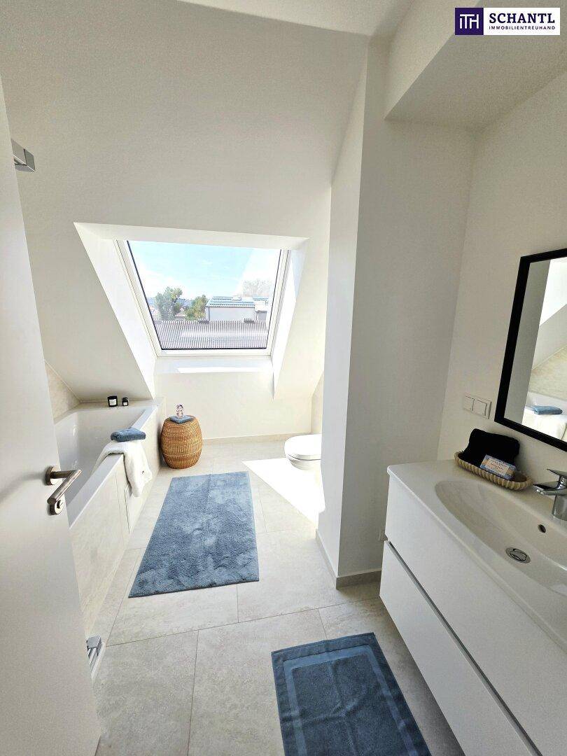 Geräumiges Badezimmer im Dachgeschoss mit Badewanne, Waschtisch und großem Dachfenster.