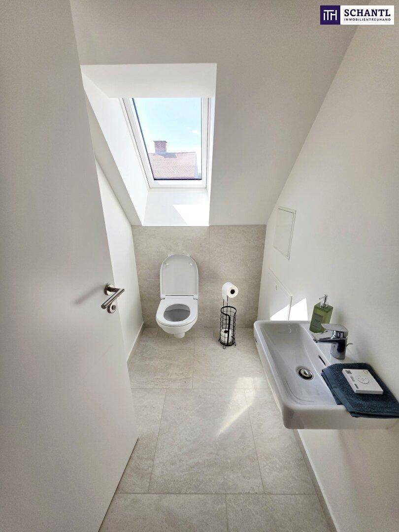 Separates Gäste-WC im Dachgeschoss mit Waschbecken, Toilette und Dachfenster.
