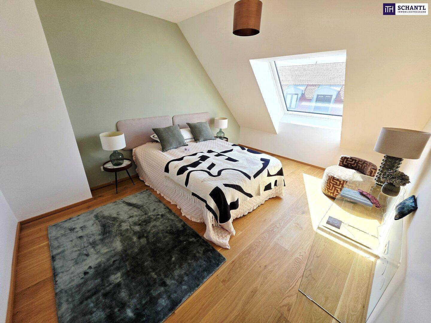 Gemütliches Schlafzimmer im Dachgeschoss mit Dachfenster, Holzboden und sanften Grüntönen.