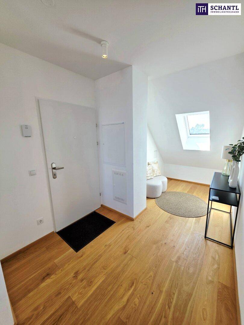 Heller Eingangsbereich mit Holzboden, Garderobe und Dachfenster, der zu den Zimmern führt.