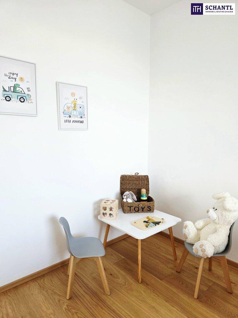 Helle Spielecke im Kinderzimmer mit kleinem Tisch, Stühlen und Spielzeug.