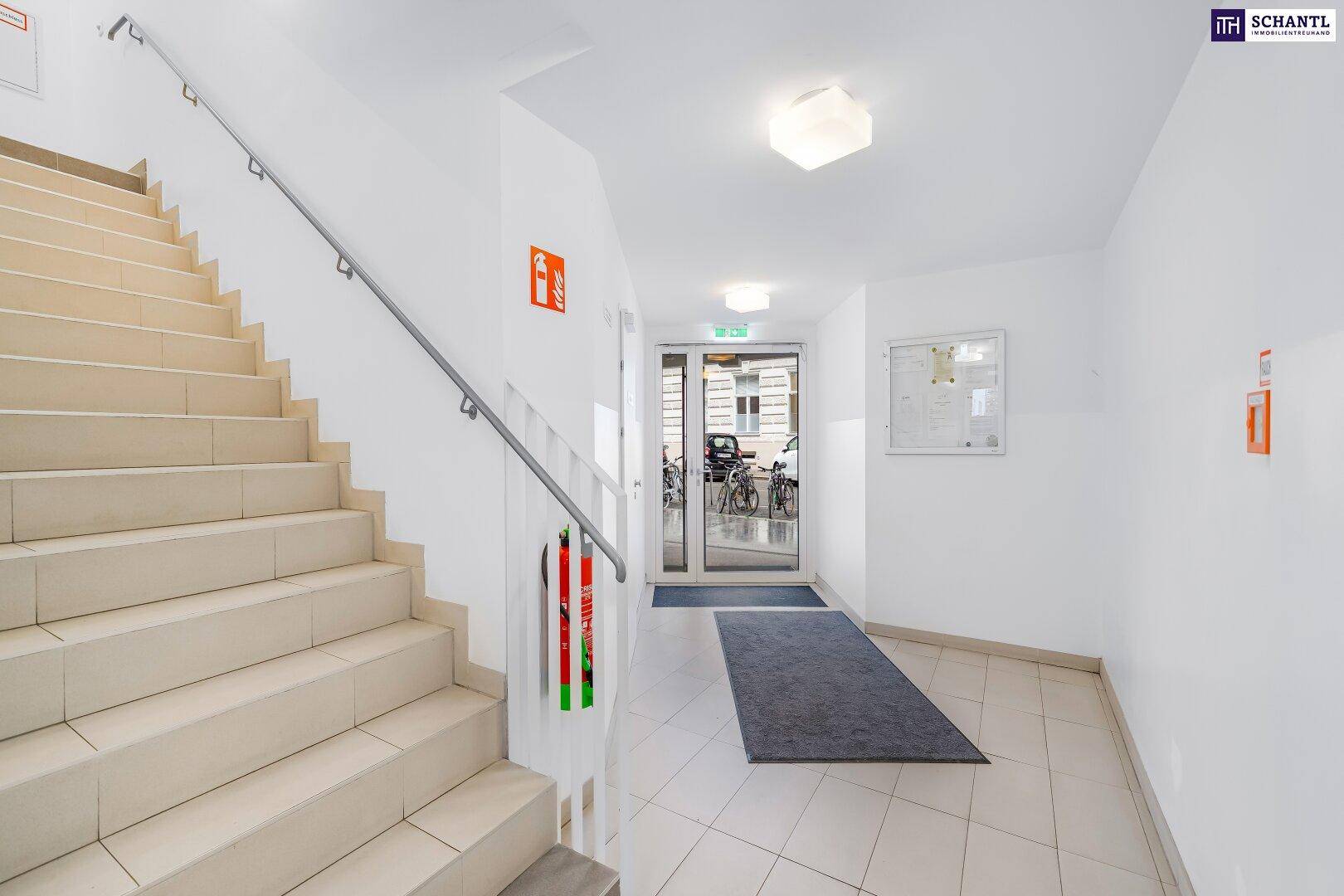 Treppenhaus und Eingangsbereich eines Gebäudes mit Rampe für Barrierefreiheit.
