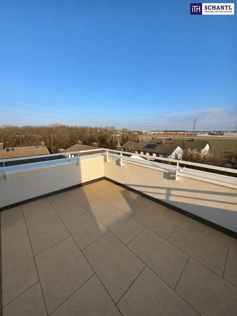 Weitläufige Dachterrasse mit Fliesenboden und Panoramablick über die Umgebung, ideal für sonnige Stunden.