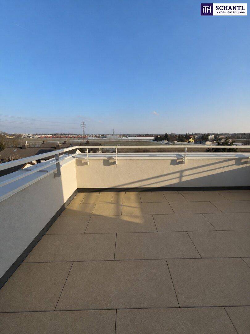 Weitläufige Dachterrasse mit Fliesenboden und Panoramablick über die Umgebung, ideal für sonnige Stunden.