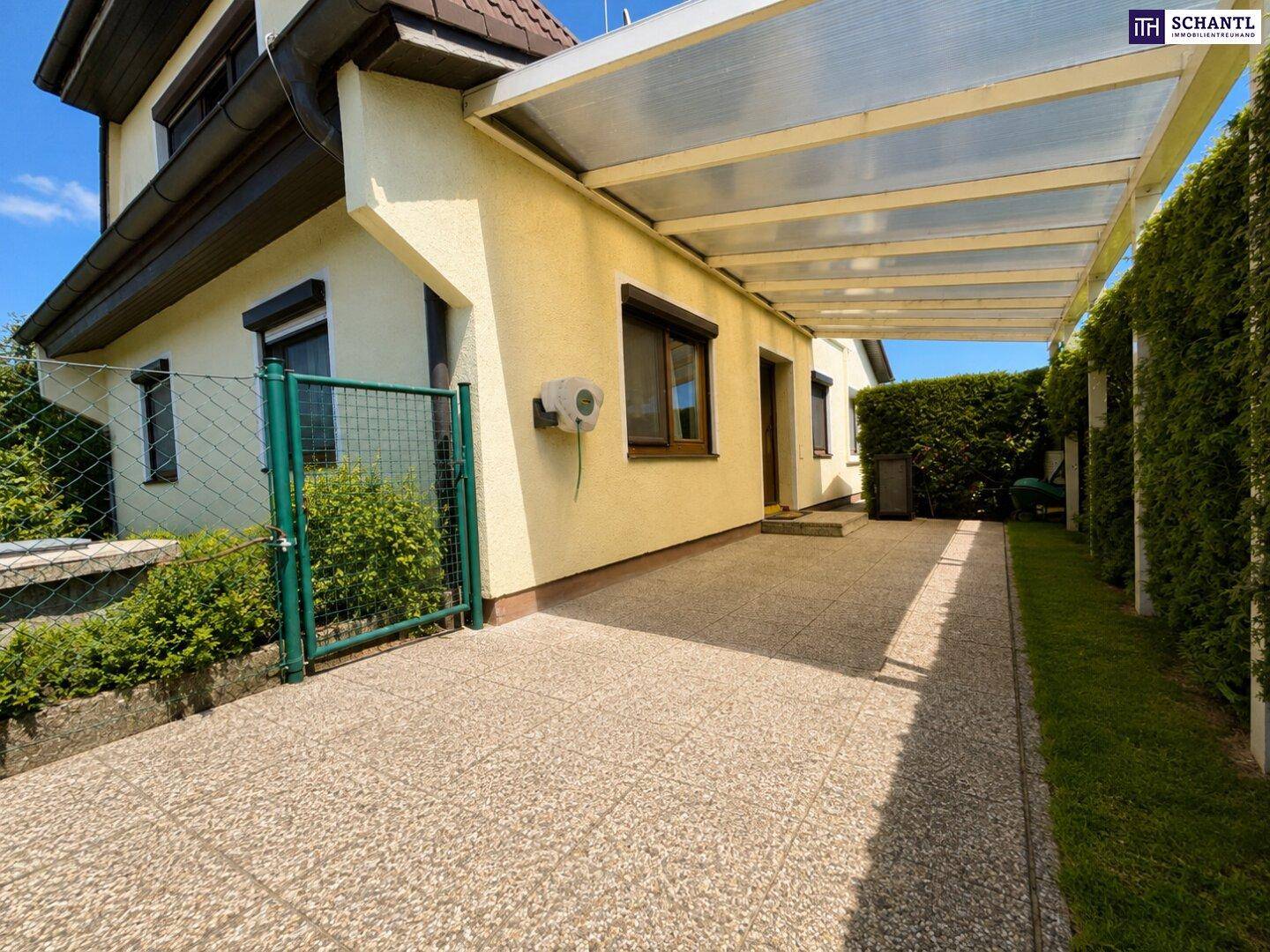 Überdachter Stellplatz neben dem Haus, bietet Schutz für Fahrzeuge vor Witterungseinflüssen.