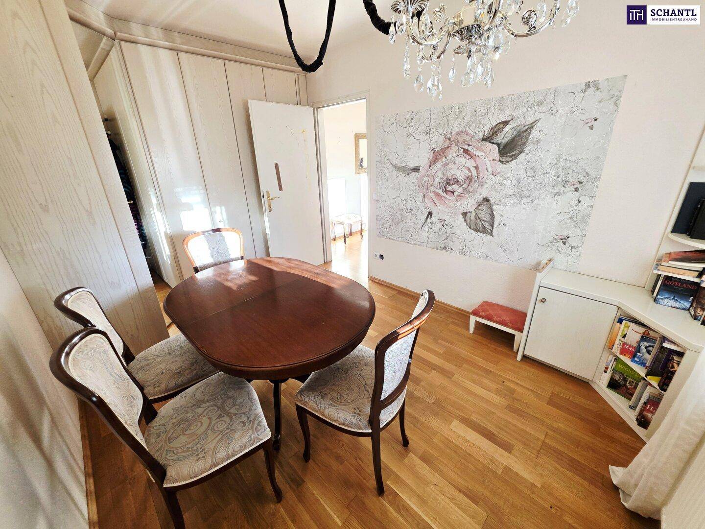 Gemütliches Esszimmer mit Holztisch, Stühlen und einem dekorativen Wandbild, durch eine Tür verbunden.