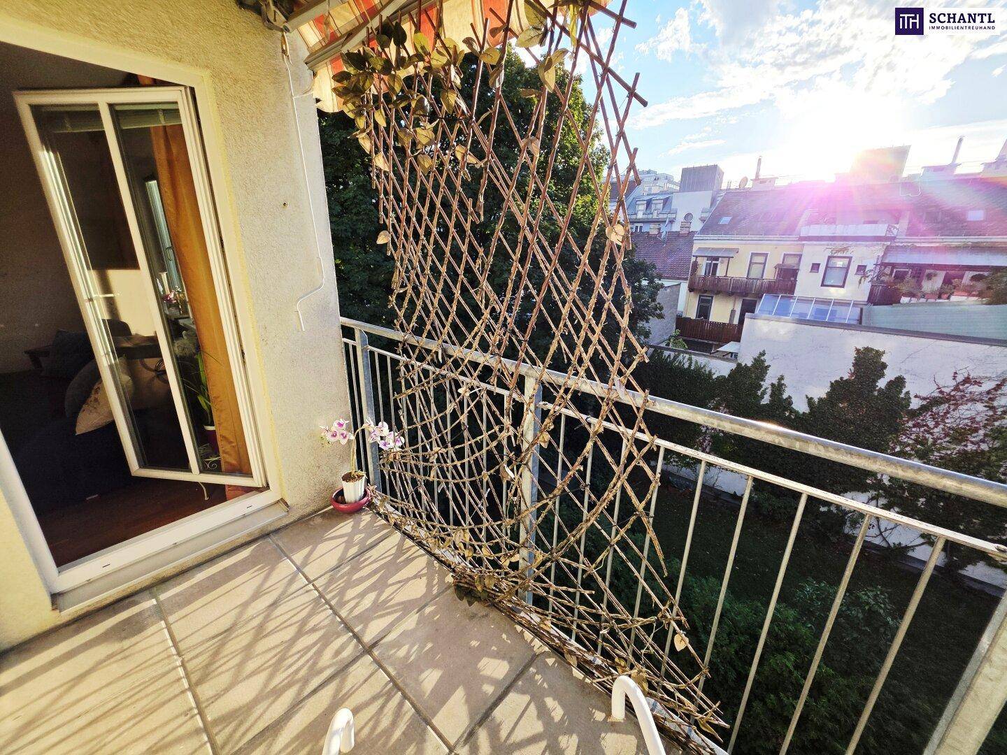 Sonniger Balkon mit Blick ins Grüne und auf die umliegenden Gebäude, ideal zum Entspannen.