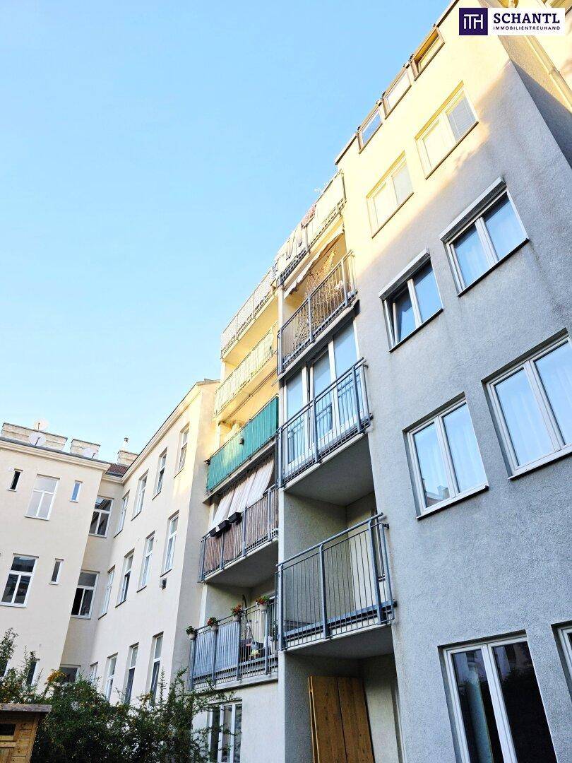 Moderne Gebäudefassade mit Balkonen und großen Fenstern unter blauem Himmel.