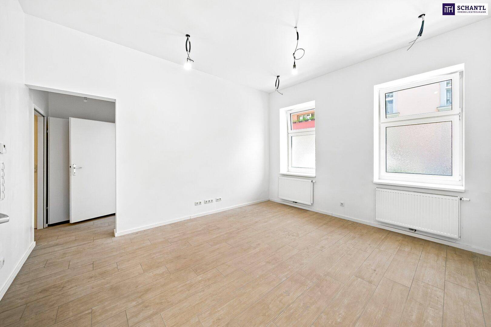 Leerer Raum mit hellem Holzfußboden und weißen Wänden, ideal für einen Wohnbereich oder Schlafzimmer.