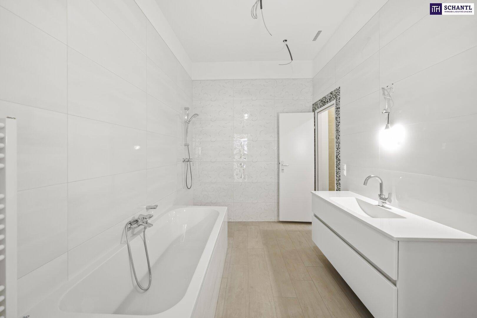 Helles Badezimmer mit weißen Fliesen, Badewanne und modernem Waschtisch, unmöbliert und geräumig.