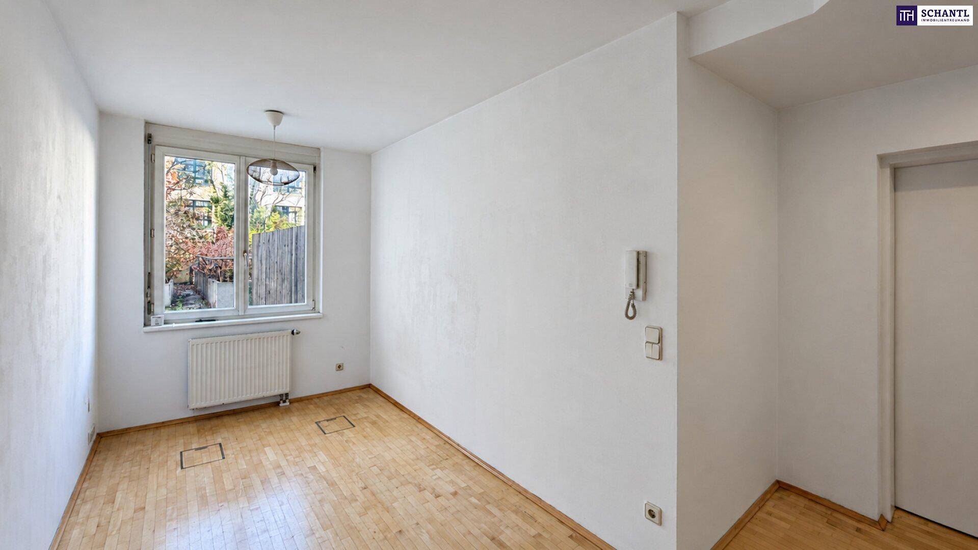 Helles Schlafzimmer mit Holzboden, großem Fenster und Blick ins Grüne.