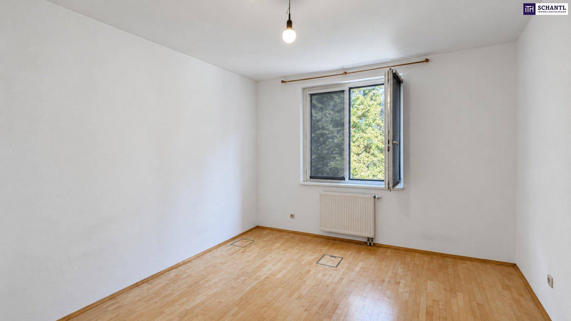 Schlafzimmer mit Holzboden und einem geöffneten Fenster, das viel Tageslicht hereinlässt.