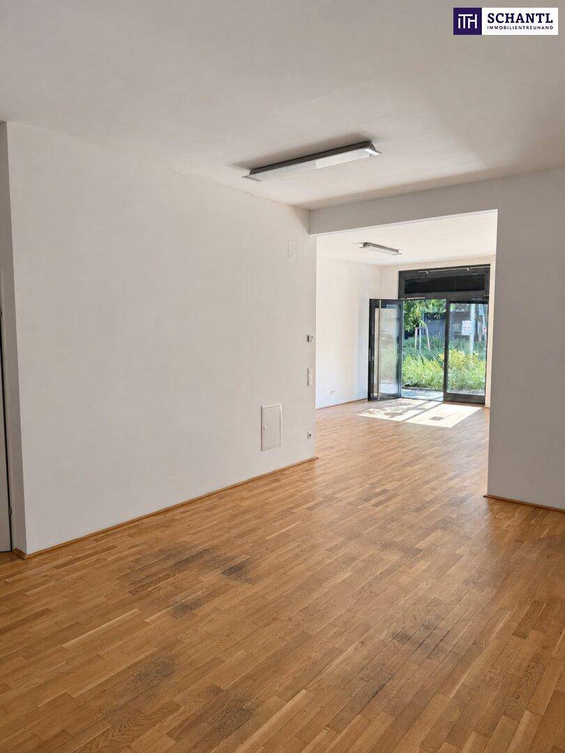 Geräumiger Innenraum mit Holzboden und weißen Wänden, bietet vielseitige Gestaltungsmöglichkeiten für ein Geschäft.