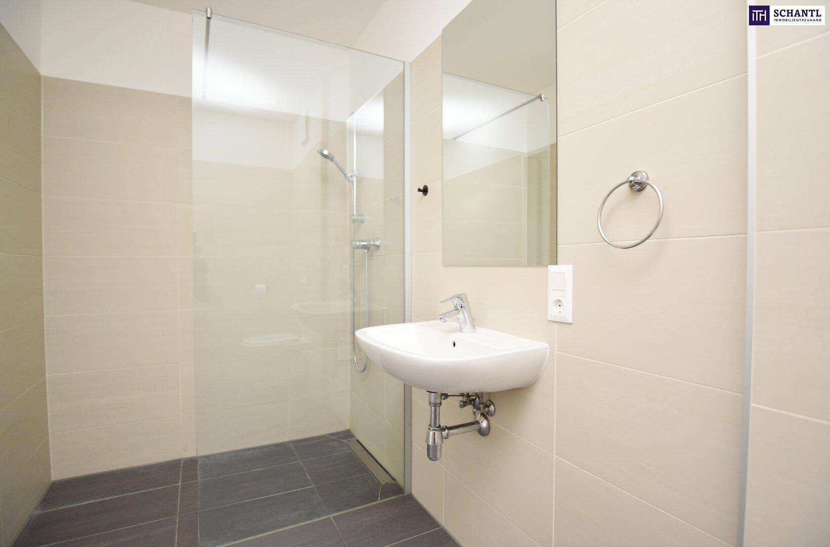Modernes Badezimmer mit begehbarer Dusche, Waschbecken und hellen Fliesen.