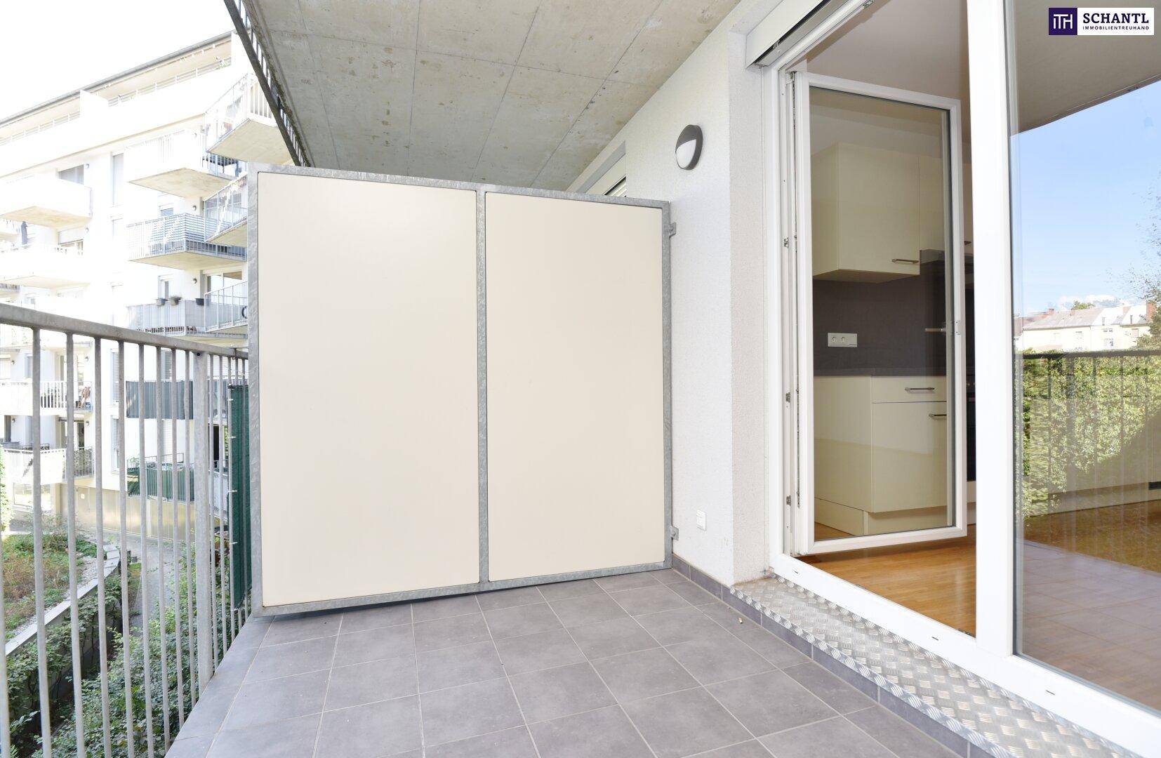 Heller Balkon mit Fliesenboden, Sichtschutz und direktem Zugang zum Wohnbereich.