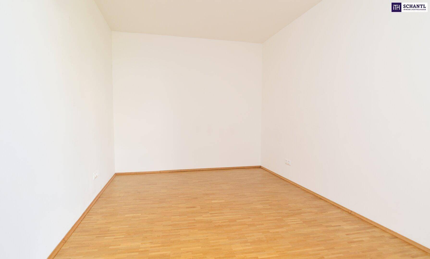 Leeres Zimmer mit hellem Parkettboden und weißen Wänden, ideal als Schlaf- oder Arbeitszimmer.