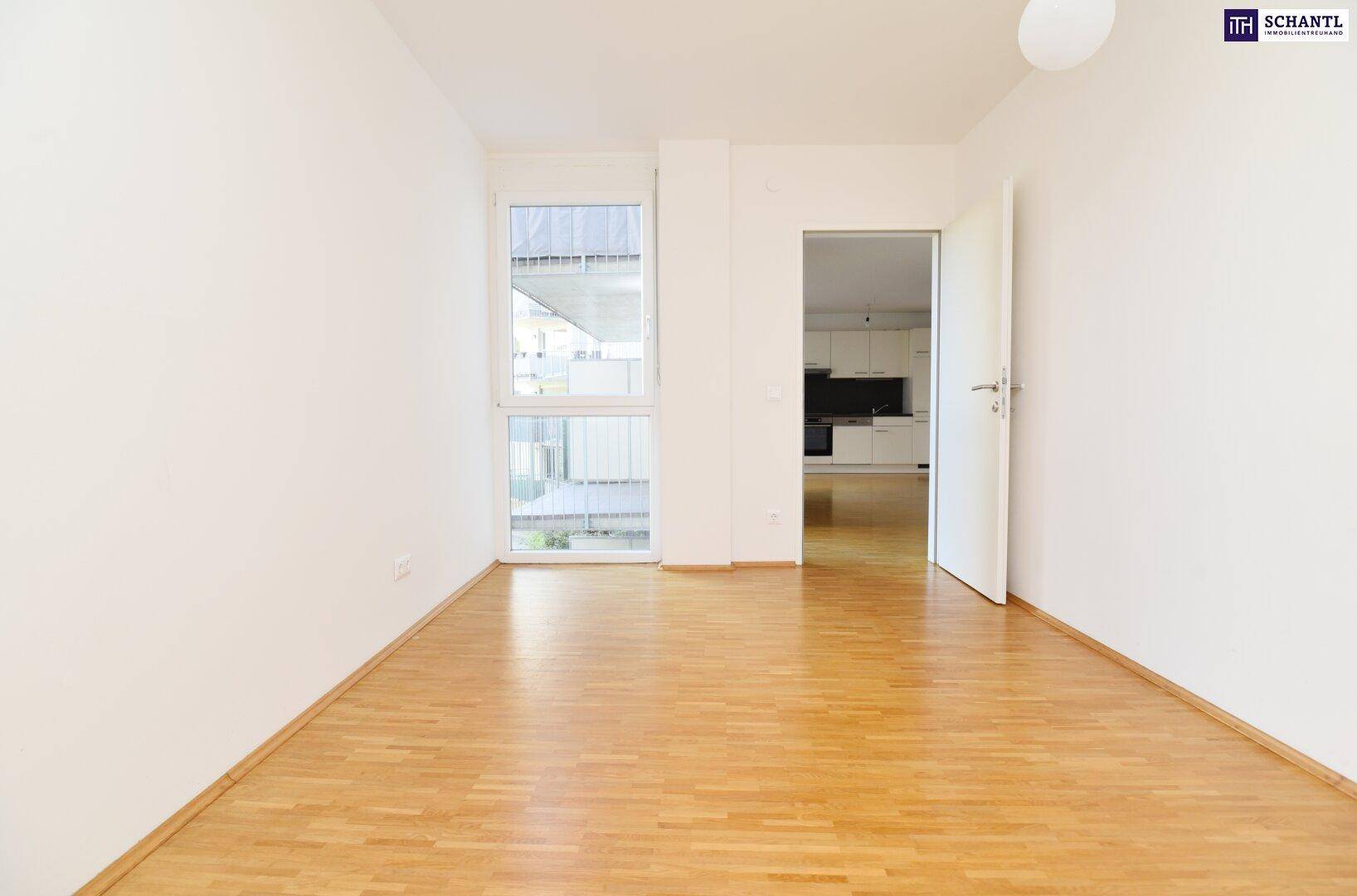 Helles Zimmer mit Parkettboden und Fenster, mit direktem Zugang zur Küche.