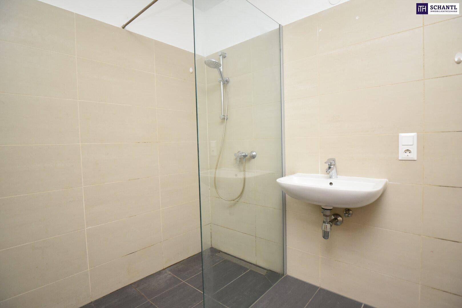 Modernes Badezimmer mit begehbarer Dusche und Waschbecken, ausgestattet mit hellen Fliesen.