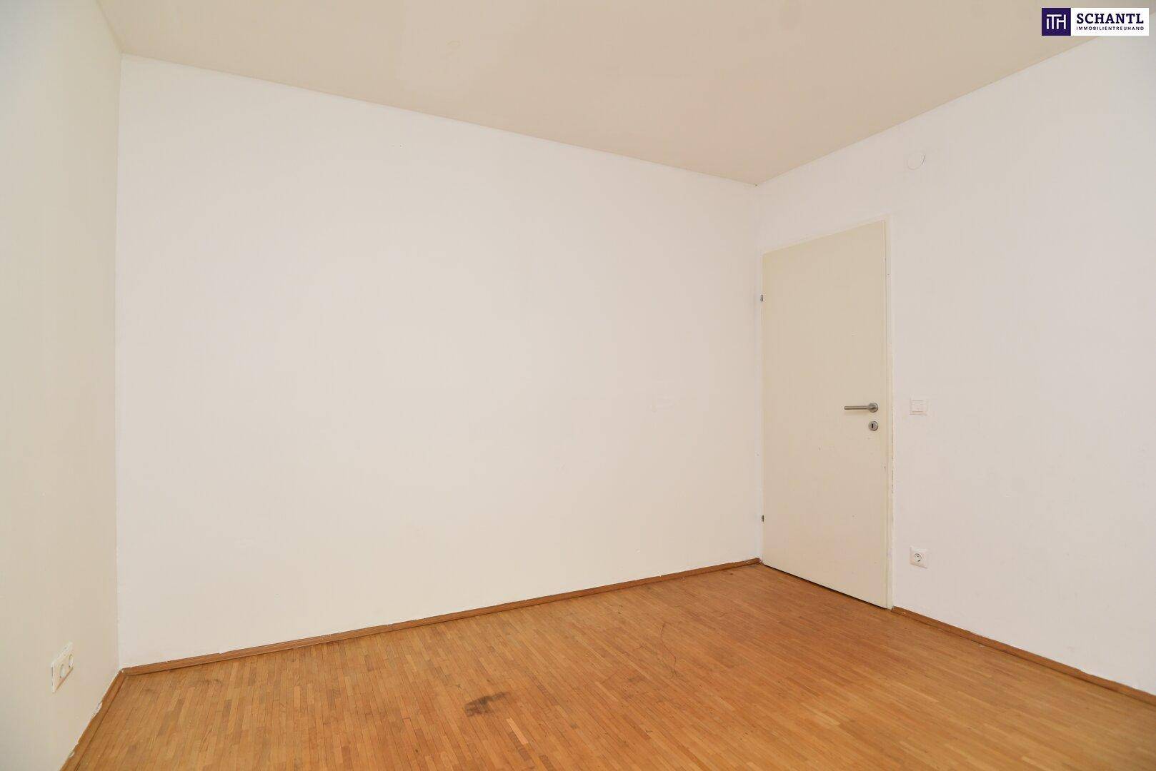 Leeres Zimmer mit Holzboden und weiß gestrichenen Wänden, bereit zur individuellen Gestaltung.