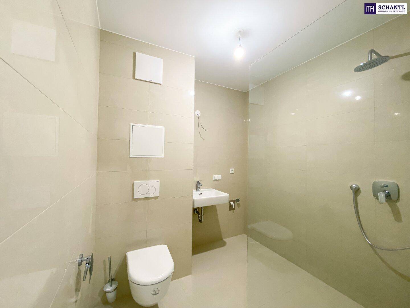 Modernes Badezimmer mit beigefarbenen Fliesen, ebenerdiger Dusche und wandhängendem WC.