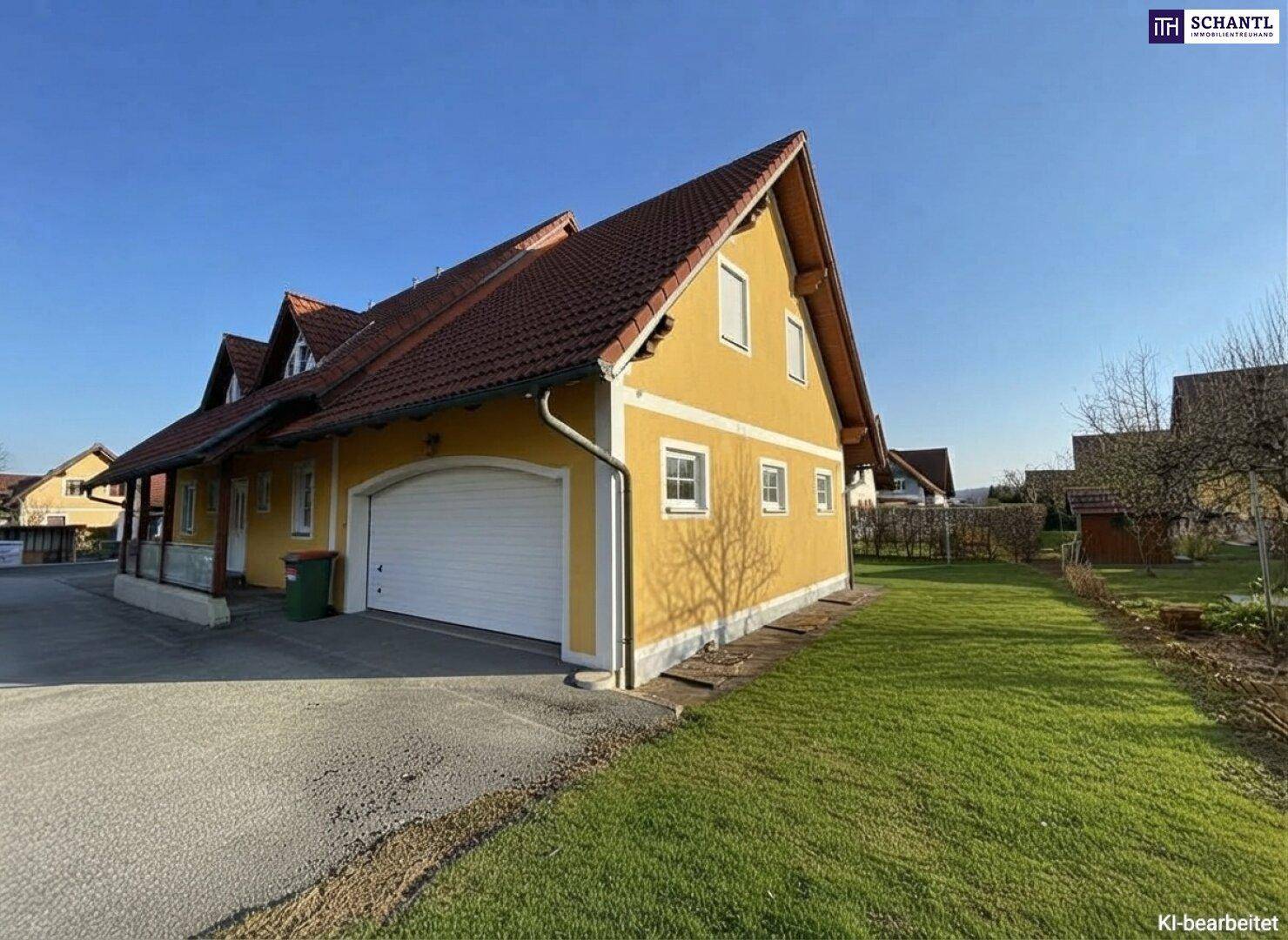 Seitenansicht des Hauses mit integrierter Garage, Zufahrt und grünem Rasenbereich.