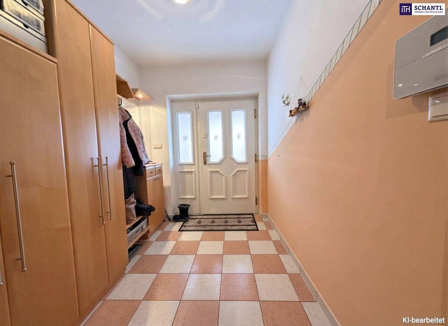 Heller Eingangsbereich mit praktischen Einbauschränken und einem karierten Fliesenboden.