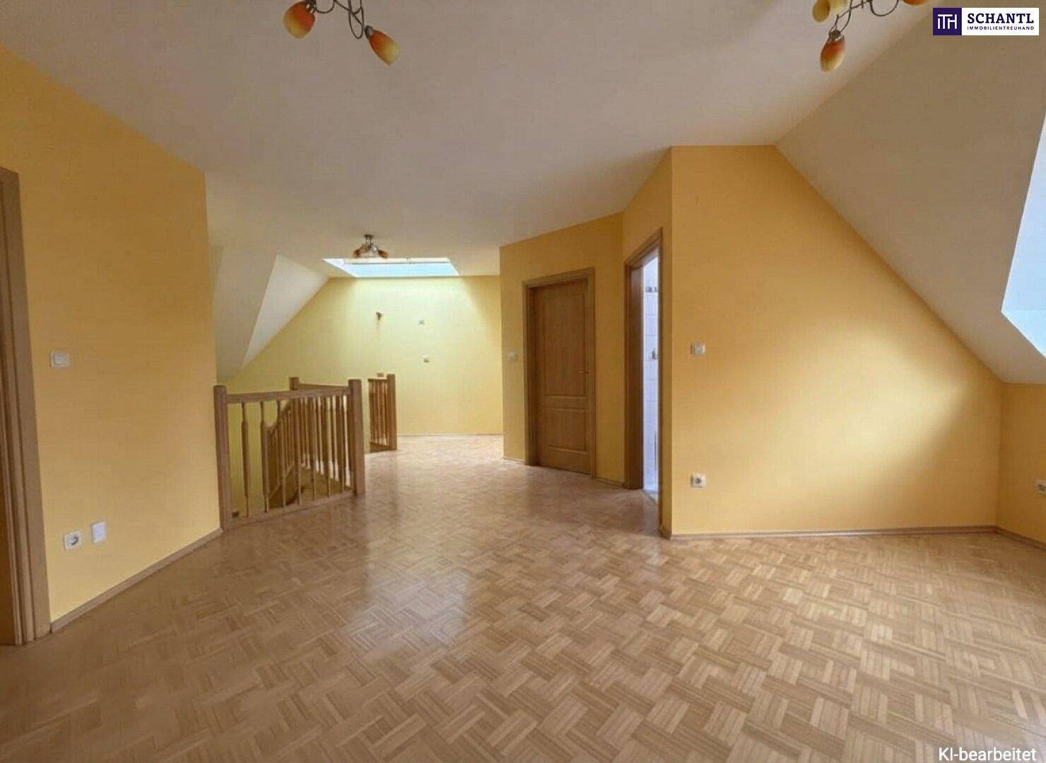 Großzügiger offener Bereich im Obergeschoss mit Parkettboden und einem Dachfenster für viel Licht.