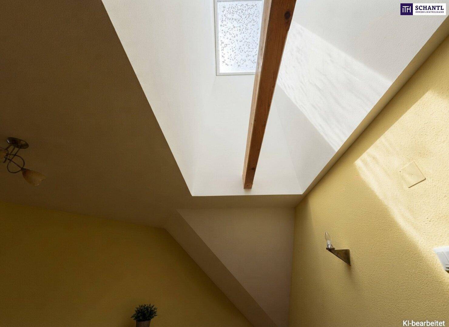 Detailansicht eines Dachfensters und eines Holzbalkens in der Dachschräge, das Licht hereinlässt.