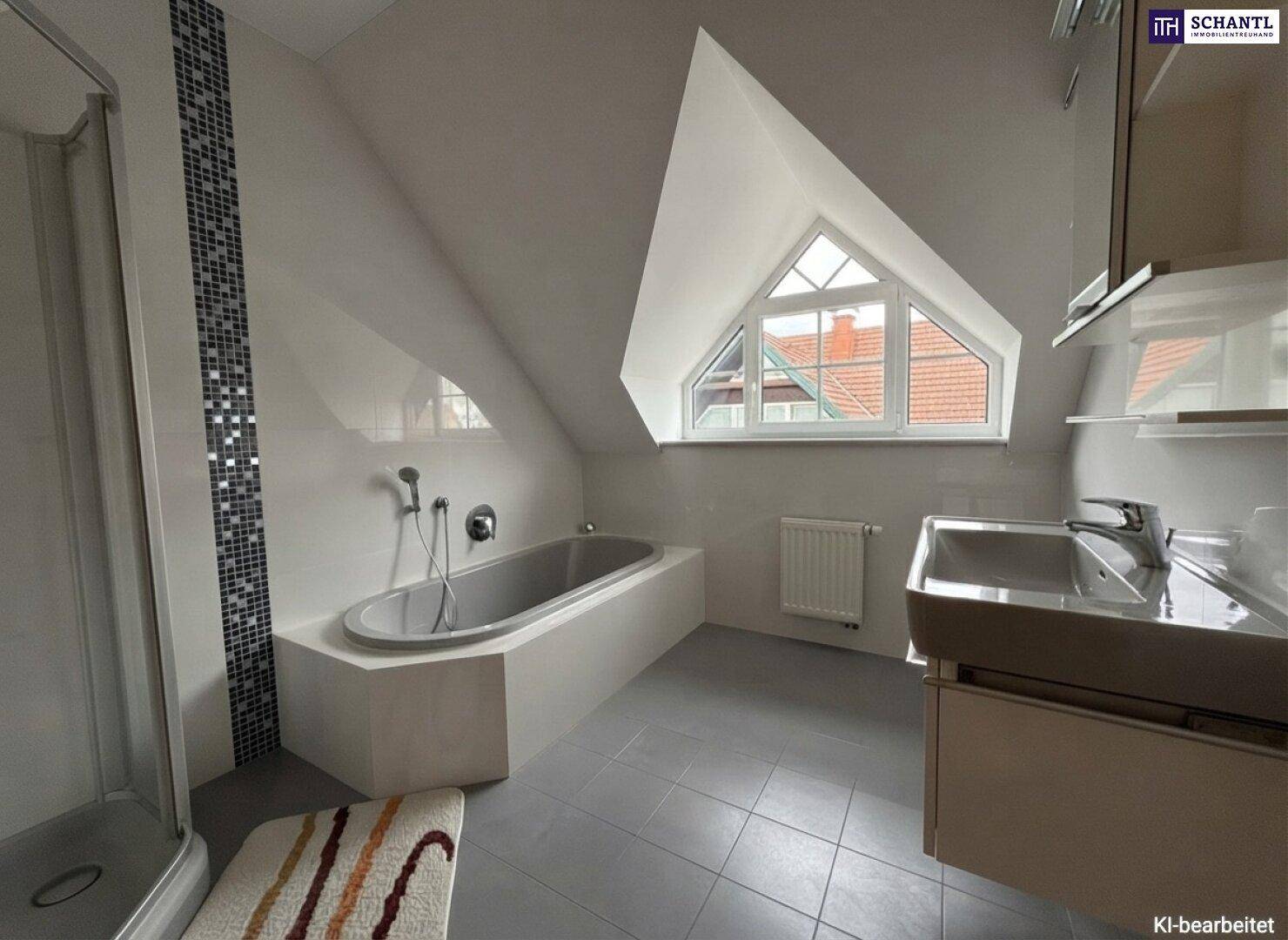 Modernes Badezimmer im Dachgeschoss mit Badewanne, Dusche und einem besonderen dreieckigen Fenster.