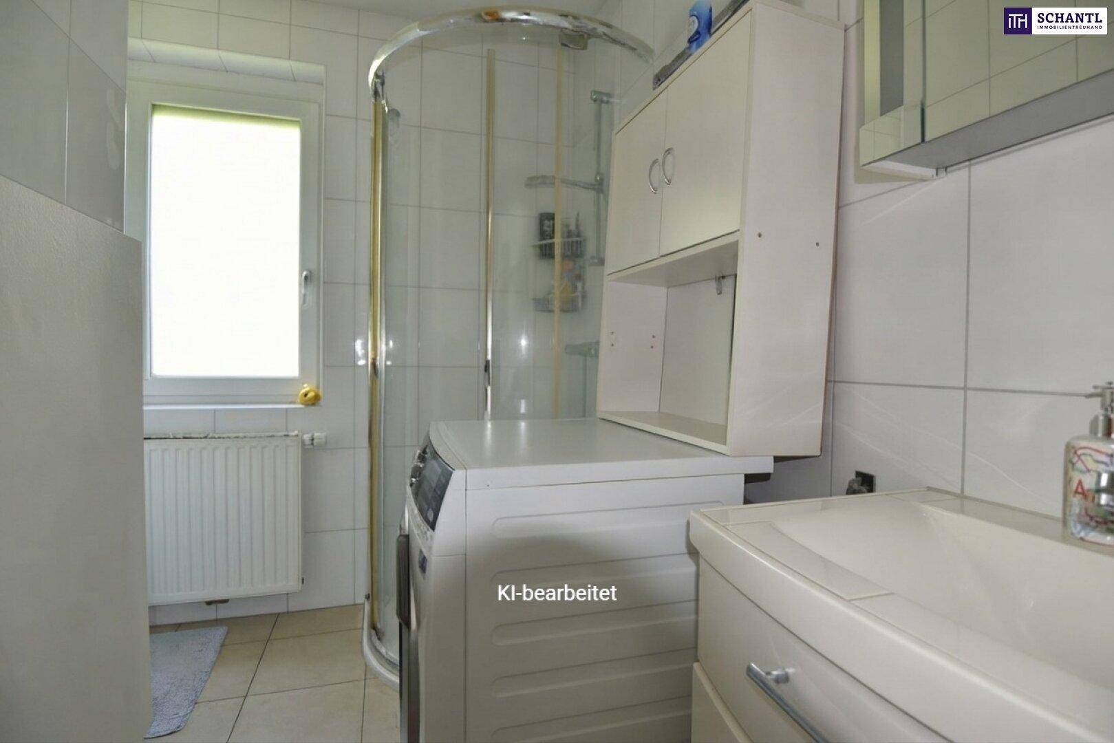 Helles Badezimmer mit Fenster, Duschkabine, Waschbecken und Waschmaschine, komplett gefliest.