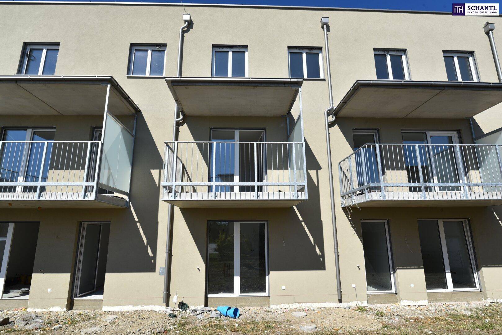 Moderne Gebäudefassade eines Neubaus mit mehreren Balkonen und großen Fenstern.