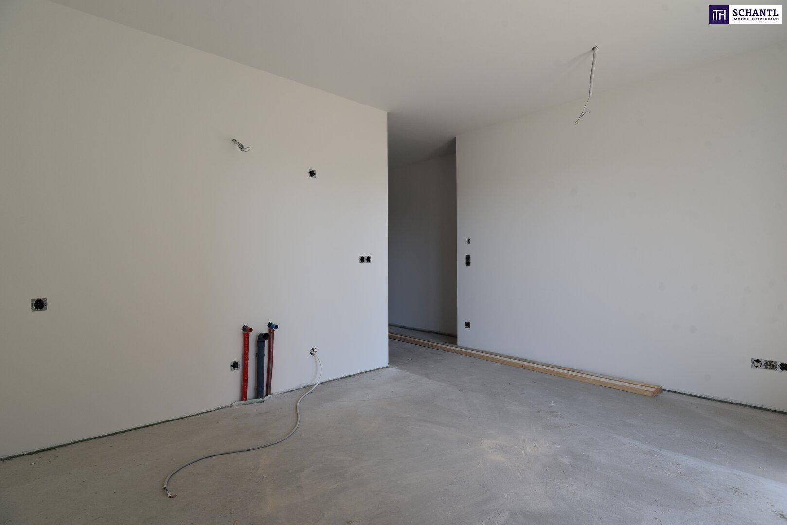 Rohbauküche mit sichtbaren Wasseranschlüssen und vorbereiteten Elektroinstallationen für die Installation.