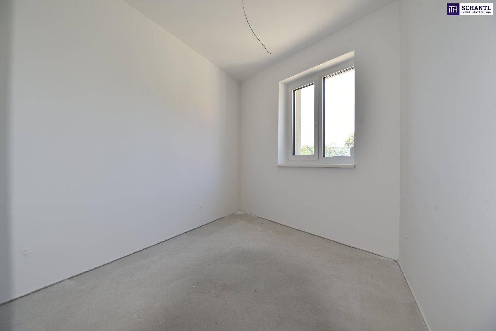 Leerer Raum im Rohbau mit einem Fenster, das natürliches Licht hereinlässt.