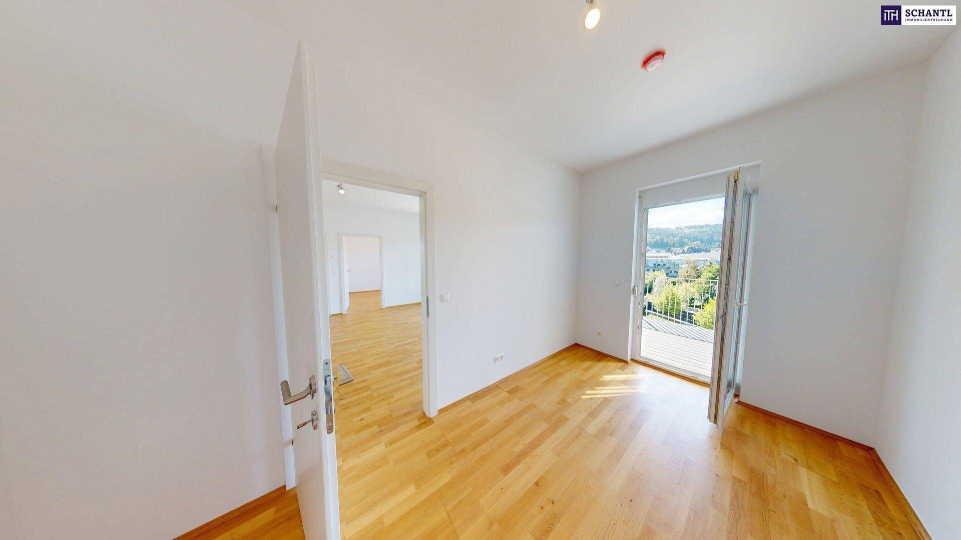 Heller Raum mit Holzboden und Zugang zu einem Balkon, ideal als Schlaf- oder Arbeitszimmer.