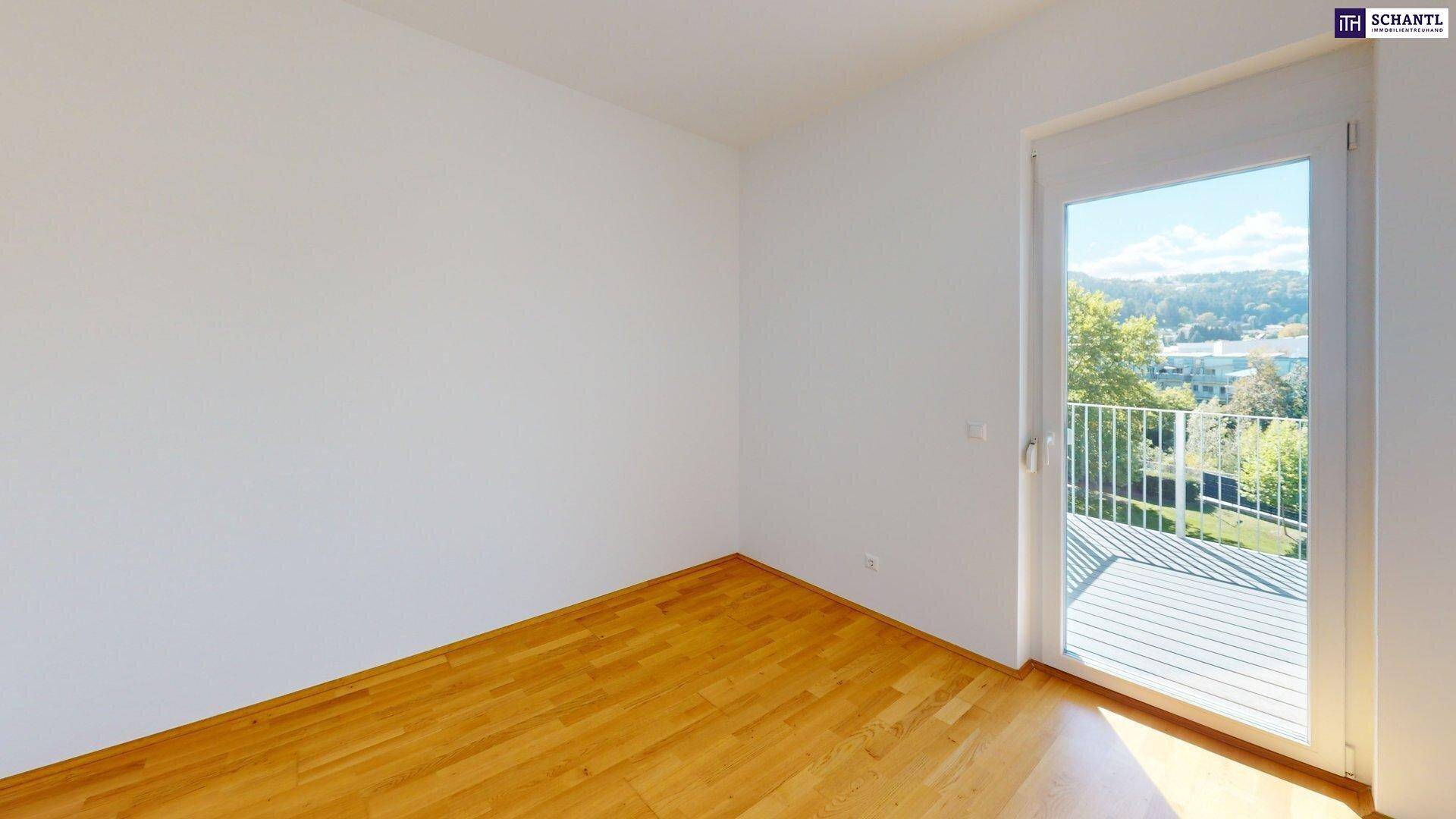 Leerer Raum mit Holzboden und Balkonzugang, bietet viel Licht und frische Luft.
