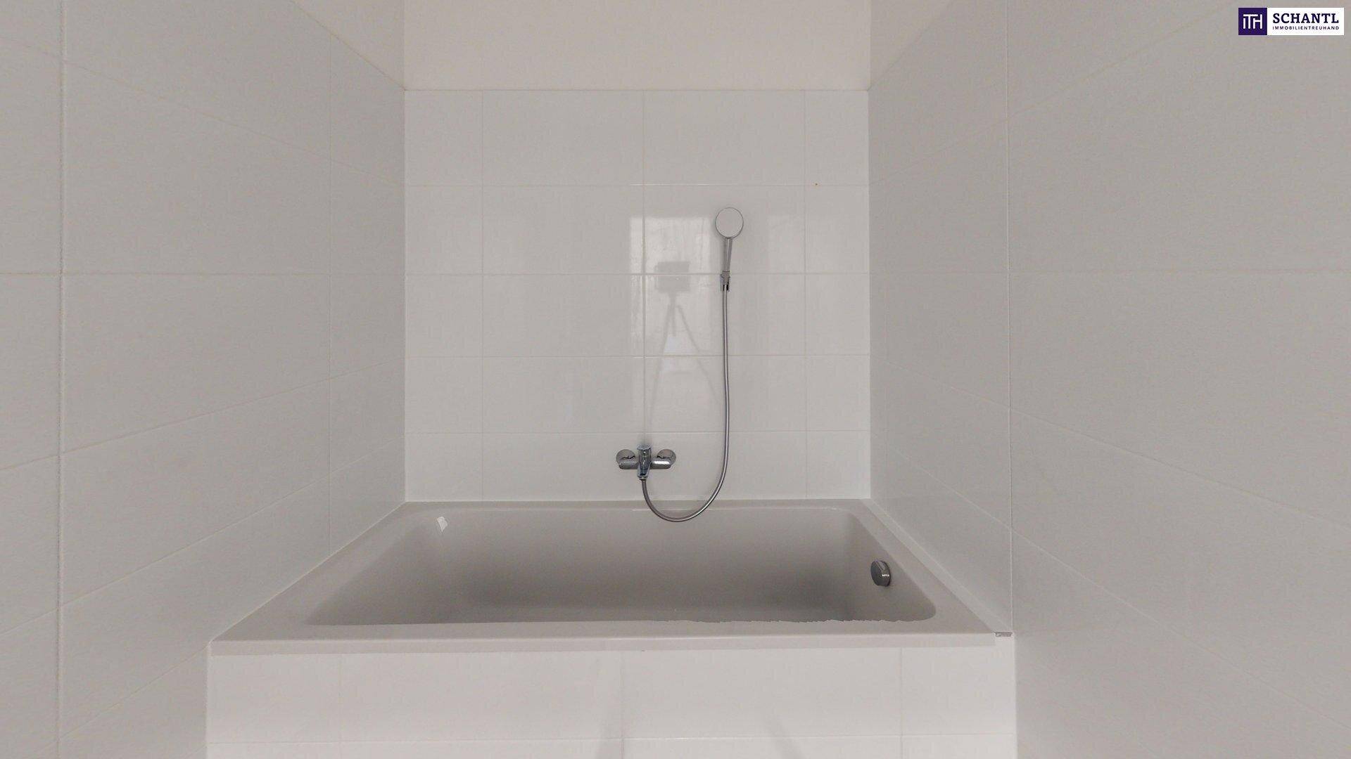 Helles Badezimmer mit integrierter Badewanne und Duschfunktion, komplett gefliest.