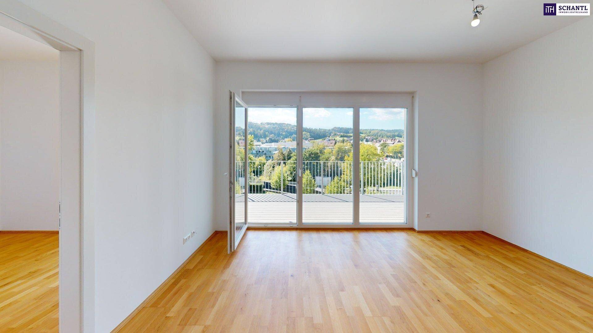 Geräumiger, heller Wohnbereich mit Holzboden und breitem Zugang zur Terrasse.